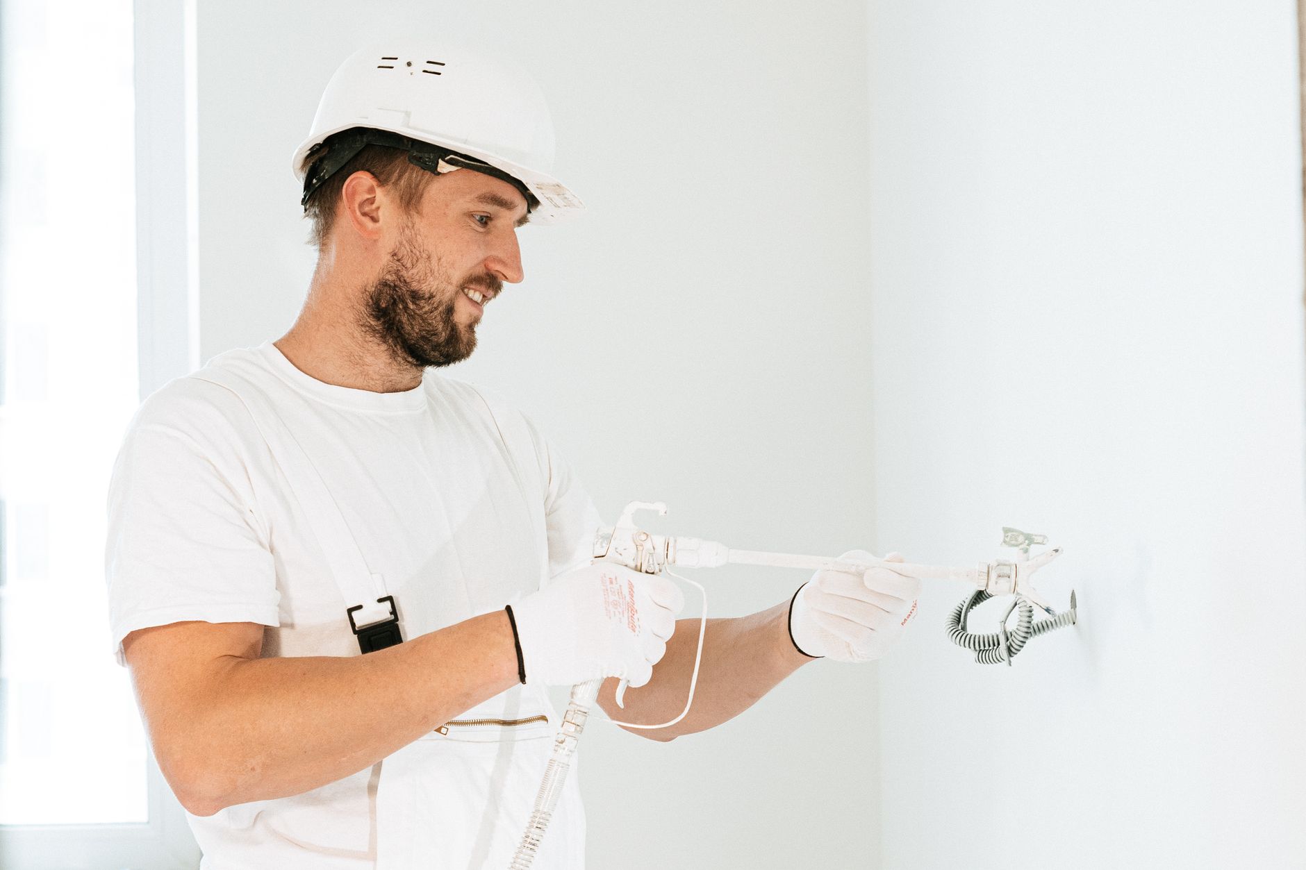 Elektriker in Schutzkleidung verlegt Leitungen in einem Neubau